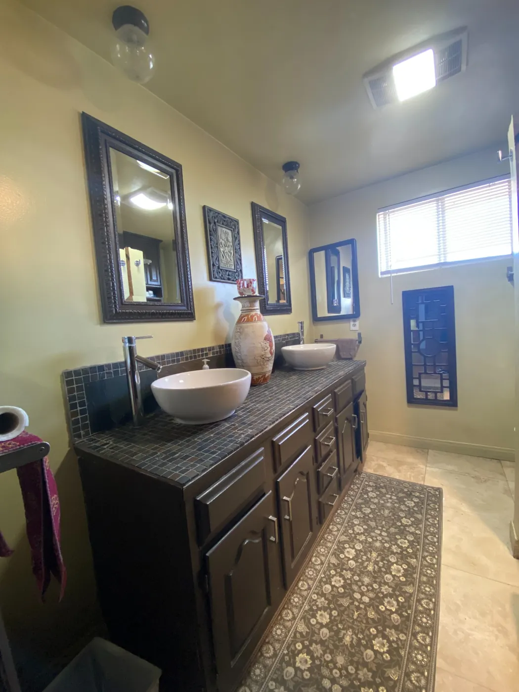 Residential bathroom vanity with two vessel sinks and a tiled countertop