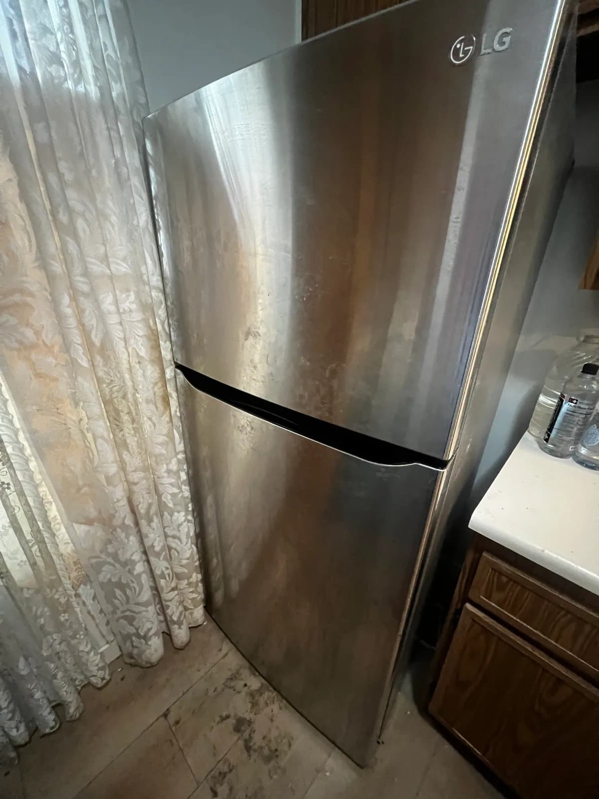 Marked stainless-steel refrigerator exterior before cleaning
